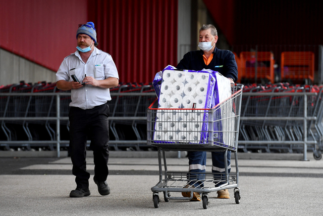 Warga membawa troli usai belanja di supermarket saat Melbourne kembali lockdown, Kamis (27/5).  Foto: WILLIAM WEST / AFP