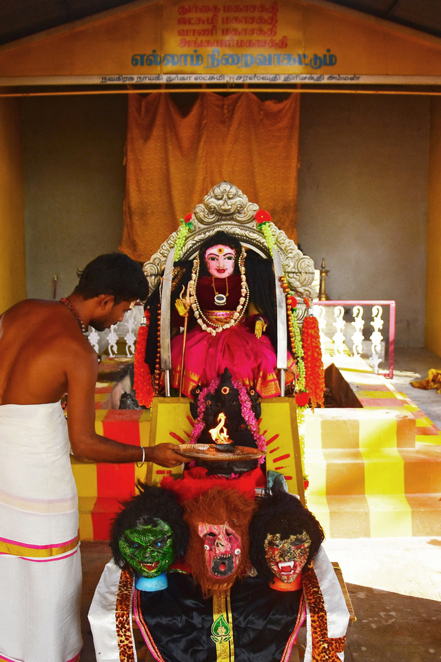 Seorang pendeta (kiri) melakukan Aarti, ritual berdoa di depan Corona Devi yang diyakini melindungi orang-orang dari virus corona di kuil Kamatchipuri Adhinam, Coimbatore, India.  Foto: AFP