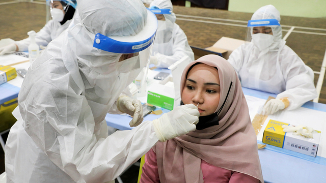 Seorang pekerja medis mengumpulkan sampel usap dari seorang wanita untuk diuji penyakit COVID-19 di Kuala Lumpur, Malaysia, (11/5). Foto: Lim Huey Teng/REUTERS