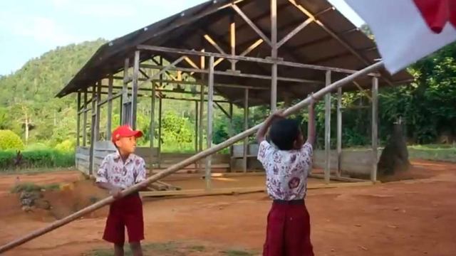 Dua siswa SD Negeri Mumpe, Kecamatan Simpang Raya, Kabupaten Banggai bendera merah putih. Sekolah ini lolos menjadi sekolah penggerak. Foto: Stephensopyan/PaluPoso