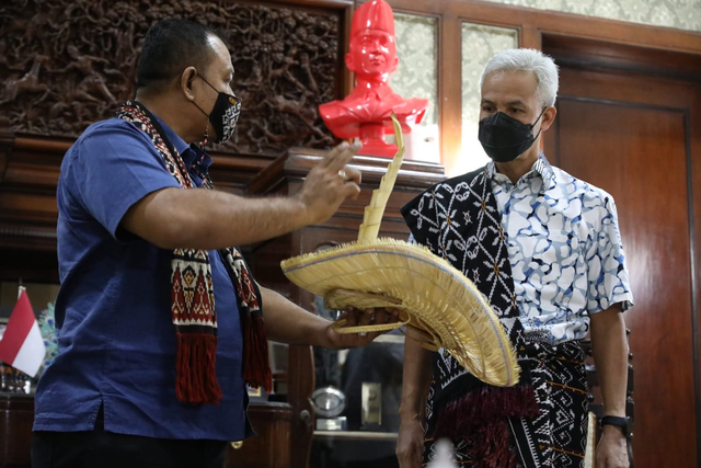 Gubernur Jawa Tengah Ganjar Pranowo menerima kain tenun dan topi khas Rote tilangga dari Raja Nusak Termanu, Rote Ndao, Nusa Tenggara Timur, Vicoas TB Amalo.  Foto: Dok. Istimewa