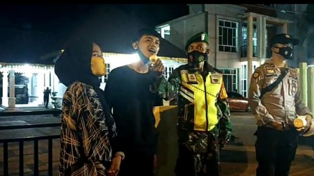 SEPASANG kekasih terjaring razia Operasi Yustisi dilakukan Satgas COVID-19 saat tak mengenakan masker di Jalan Sudirman, Bengkalis, Riau, Minggu malam (30/5/2021). 