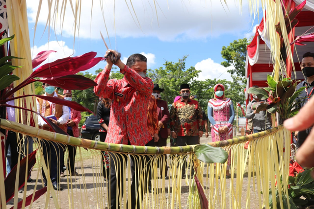 Wagub Kalbar Ria Norsan melakukan tradisi potong tebu saat hendak memasuki area pekan Gawai Dayak. Foto: Dok Hi!Pontianak
