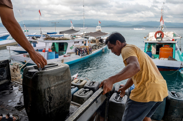 Pekerja menurunkan BBM jenis solar ke kapal nelayan di Pelabuhan Pendaratan Ikan (PPI) Donggala, Sulawesi Tengah, Selasa (1/6/2021). Foto: Basri Marzuki/Antara Foto