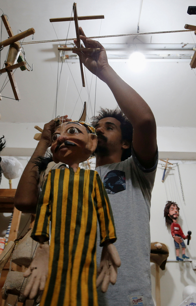 Mohamed Fawzy Bakkar menunjukkan boneka buatan tangannya di Kairo, Mesir. Foto: Amr Abdallah Dalsh/REUTERS