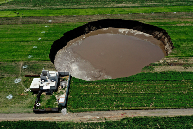 Foto udara lubang besar yang tiba-tiba muncul di sebuah ladang pertanian di Santa Maria Zacatepec, negara bagian Puebla, Meksiko. Foto: JOSE CASTANARES / AFP