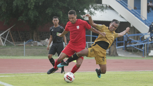 Pemain Persis Solo (merah) berebut bola dengan pemain Bhayangkara Solo FC dalam laga uji coba di Stadion UNS
