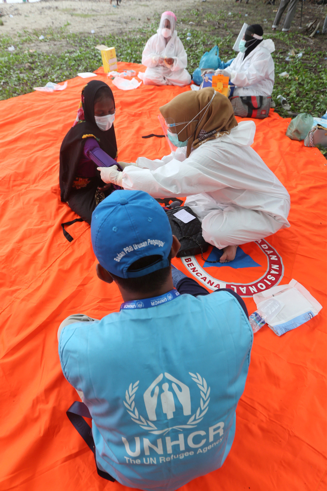 Petugas memeriksa kesehatan pengungsi etnis Rohingya sebelum disuntik vaksin setelah dilakukan pendataan oleh United Nations High Commissioner for Refugees (UNHCR), International Organization for Migration (IOM) dan Imigrasi di Aceh Timur, Aceh. Foto: Irwansyah Putra/ANTARA FOTO
