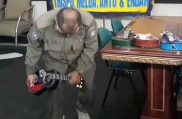 Petugas mematahkan gitar ukulele milik pengamen yang terjaring razia. Foto: Dok Hi!Pontianak