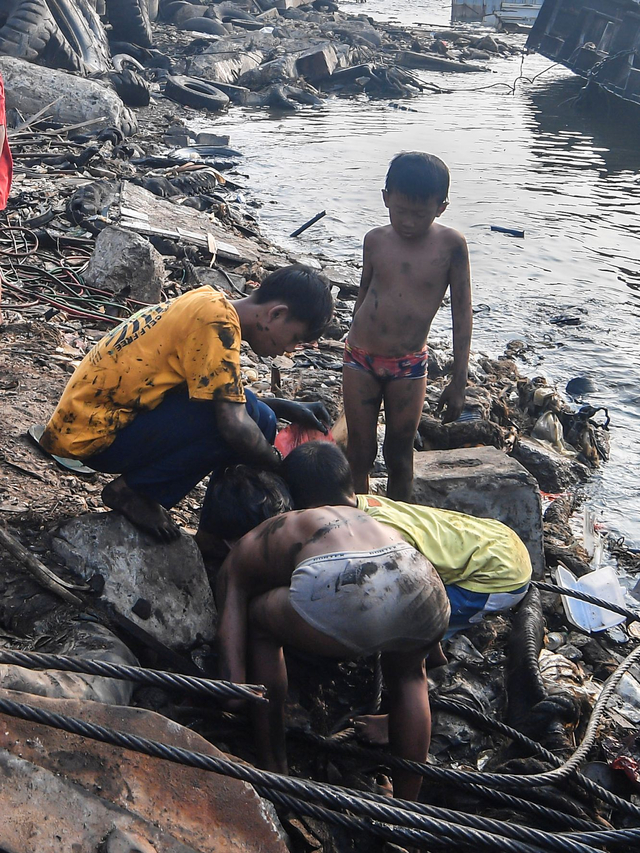 Sejumlah bocah mencari sisa besi bekas di lokasi kapal yang dibelah di Cilincing, Jakarta, Minggu (6/6/2021). Foto: Muhammad Adimaja/Antara Foto