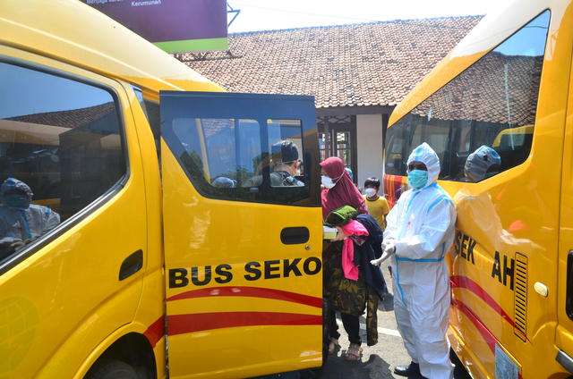 Sejumlah pasien COVID-19 naik ke bus sekolah saat akan dipindahkan dari Kudus di Jawa Tengah, Senin (7/6/2021). Foto: Yusuf Nugroho/Antara Foto