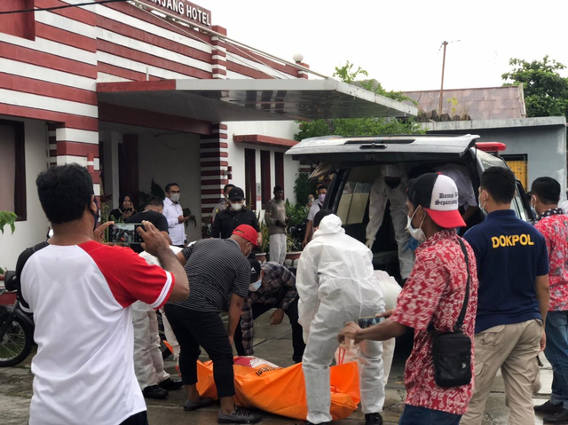 Polisi menggunakan APD saat mengevakuasi jenazah korban yang ditemukan meninggal dunia di kamar hotel di Ternate. Foto: Samsul Hi Laijou/cermat