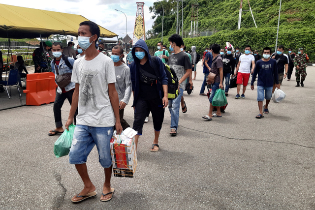 Sejumlah Pekerja Migran Indonesia (PMI) dari Malaysia memasuki perbatasan Indonesia di Pos Lintas Batas Negara (PLBN) Entikong, Kabupaten Sanggau, Kalimantan Barat, Kamis (20/5). Foto: Agus Alfian/ANTARA FOTO