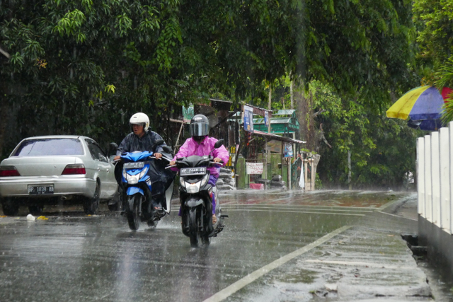 Pengendara sepeda motor berkendara di tengah derasnya hujan. Foto: Ismail/kepripedia.com