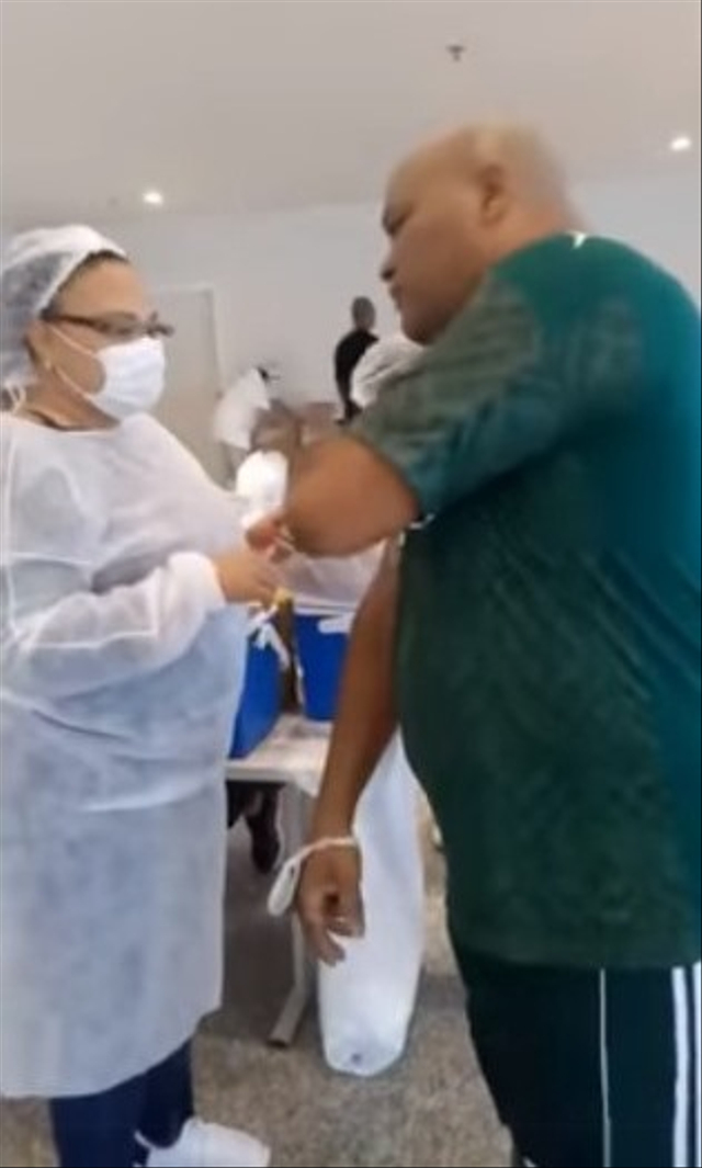 Momen pria di Brasil bernama Maguila Junior satuh pingsan saat hendak disuntik vaksin karena fobia jarum suntik (Foto: Facebook/@Maguila Junior)