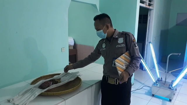 Petugas tengah melihat sosok bayi perempuang yang sudah meninggal dan ditemukan dalam kantong plastik.