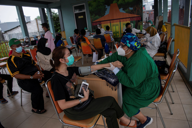 Petugas kesehatan memeriksa kesehatan calon penerima vaksin COVID-19 di RPTRA Bandar Kemayoran, Jakarta Pusat, Jumat (11/6/2021). Foto: Sigid Kurniawan/Antara Foto