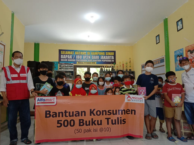 Anak anak Kampung Sinau menerima bantuan paket buku dari Alfamart. foto/sholeh