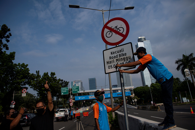 Petugas Dinas Perhubungan mencopot rambu bertuliskan kecuali road bike di sekitar Jalan Layang Non Tol (JLNT) Casablanca, Jakarta, Minggu (13/6/2021). Foto: Sigid Kurniawan/Antara Foto