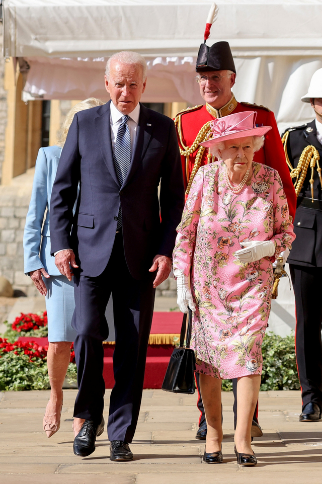 Presiden AS Joe Biden (kanan) berjalan dengan Ratu Inggris Elizabeth II di Kastil Windsor di Windsor, barat London, pada Minggu (13/6). Foto: Chris Jackson/POOL/AFP