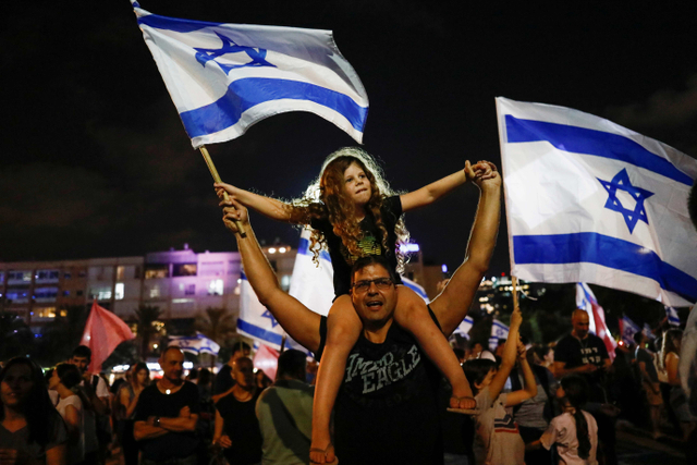Anak-anak terlihat ikut merayakan kemenangan pemerintahan koalisi baru di Rabin Square di Tel Aviv, Israel. Foto: Corinna Kern/Reuters