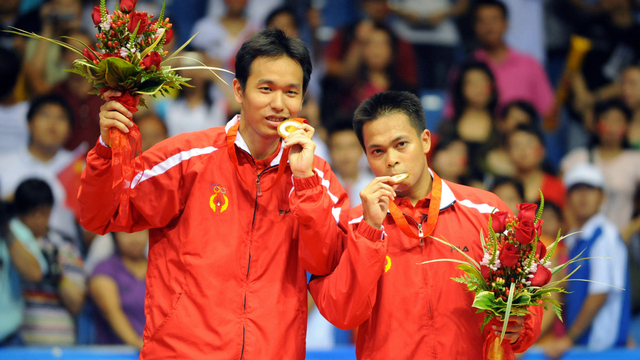 Markis Kido (kanan) dan Hendra Setiawan dari Indonesia mengangkat medali emas mereka di Olimpiade Beijing 2008 di Beijing pada 16 Agustus 2008. Foto: GOH CHAI HIN/AFP