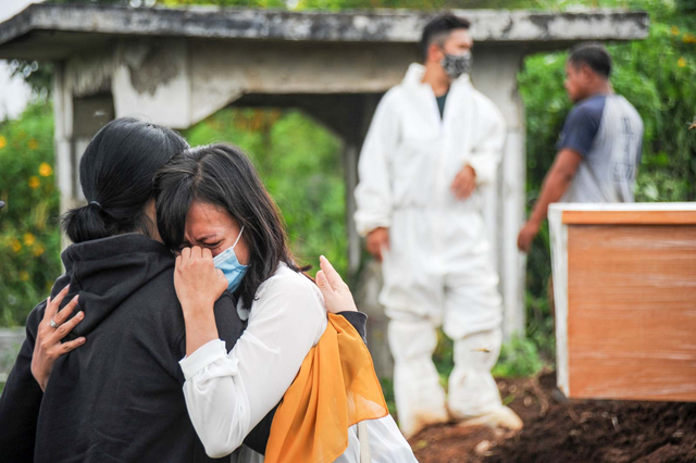 Keluarga menangis saat menyaksikan pemakaman jenazah dengan protokol COVID-19 di TPU Cikadut, Bandung, Jawa Barat, Selasa (15/6/2021). Foto: Raisan Al Farisi/ANTARA FOTO