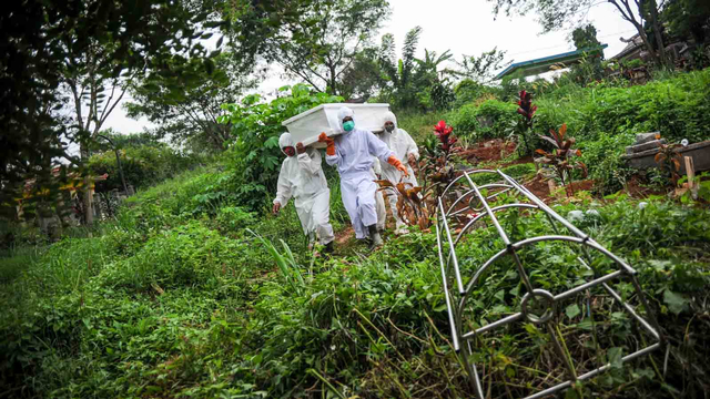 Tenaga pikul membawa jenazah dengan protokol COVID-19 untuk dimakamkan di TPU Cikadut, Bandung, Jawa Barat, Selasa (15/6/2021). Foto: Raisan Al Farisi/ANTARA FOTO
