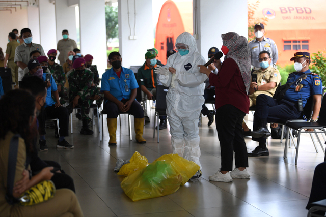 Tenaga kesehatan mencontohkan pemakaian alat pelindung diri untuk penanganan pasien COVID-19 di Rumah Susun Nagrak, Cilincing, Jakarta Utara, Selasa (15/6). Foto: Sigid Kurniawan/ANTARA FOTO