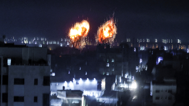 Ledakan terlihat di atas gedung-gedung di Kota Gaza saat pasukan Israel menembaki daerah kantong Palestina, Rabu (16/6). Foto: MAHMUD HAMS/AFP