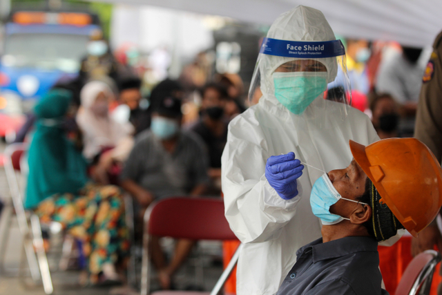 Tenaga kesehatan melakukan tes Antigen kepada warga saat penyekatan di akses masuk Jembatan Suramadu, Surabaya, Jawa Timur, Kamis (17/6).  Foto: Didik Suhartono/ANTARA FOTO