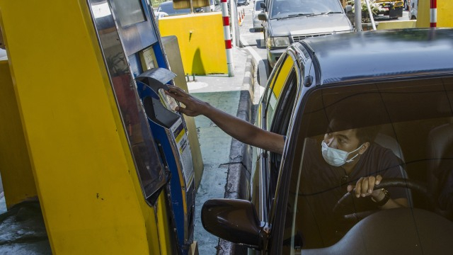 Pengendara mobil melakukan transaksi e-toll saat keluar Gerbang Tol Pasteur. Foto: Novrian Arbi/Antara