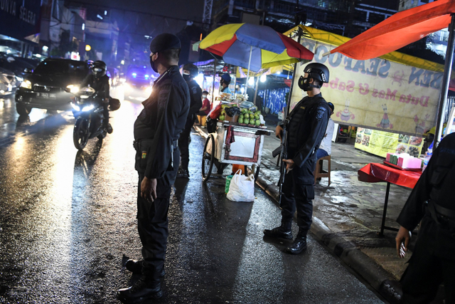 Personel kepolisian melakukan patroli pengawasan protokol kesehatan di kawasan kuliner Jalan Sabang, Jakarta, Jumat (18/6). Foto: Hafidz Mubarak A/ANTARA FOTO
