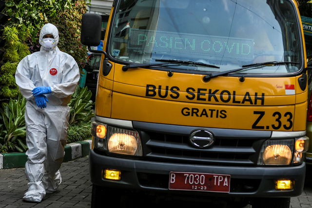 Petugas kesehatan bersiap mengantar pasien COVID-19 menuju Rumah Sakit Darurat Covid (RSDC) Wisma Atlet Kemayoran di Puskesmas Menteng, Jakarta. Foto: Galih Pradipta/Antara Foto