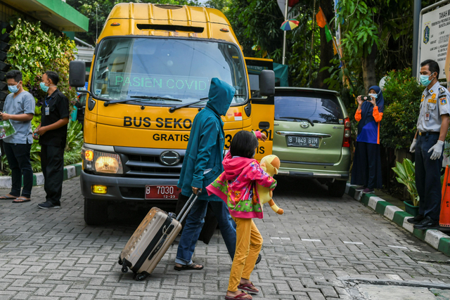 Pasien COVID-19 bersiap memasuki bus sekolah untuk menuju Rumah Sakit Darurat Covid (RSDC) Wisma Atlet Kemayoran di Puskesmas Menteng, Jakarta. Foto: Galih Pradipta/Antara Foto
