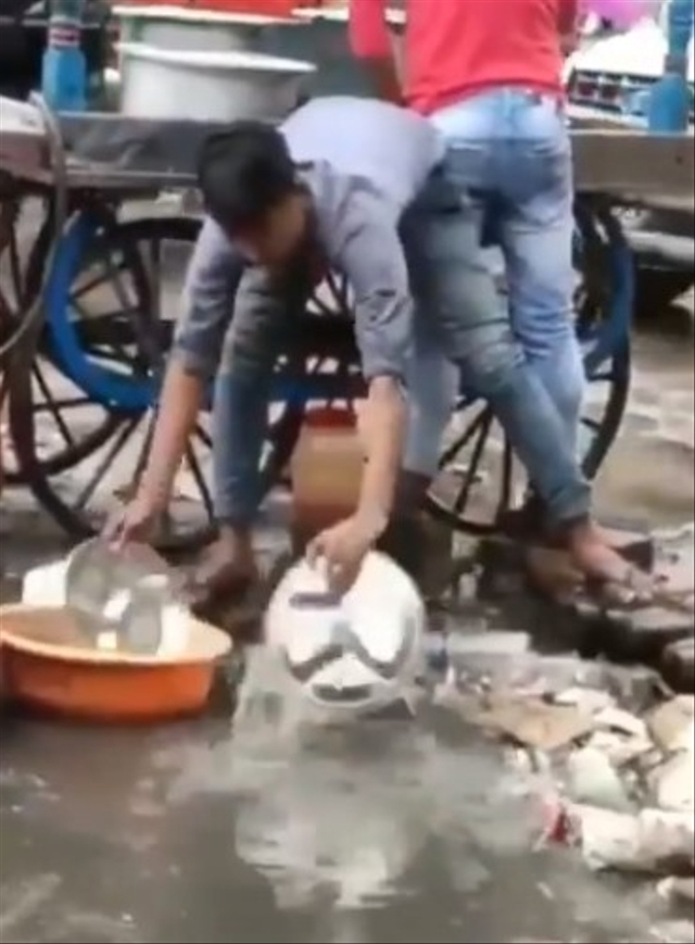 Momen menjijikan seorang pedagang jajanan diduga di India mencuci piring menggunakan air comberan. (Foto: Twitter/@friendthefun_)
