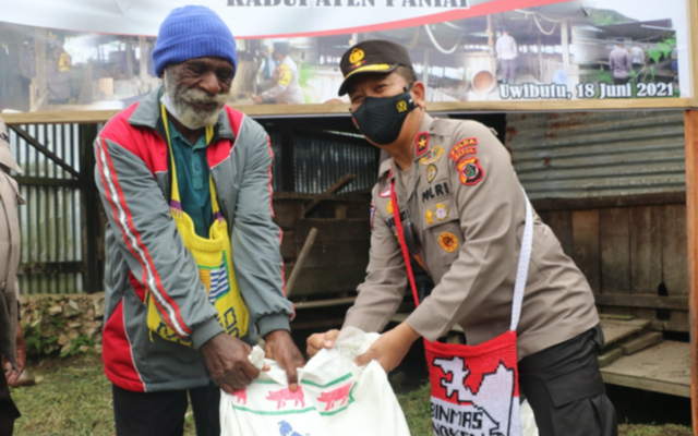 Yulius Gobai, peternak di Paniai menerima pakan ternak babi dari Binmas Noken Polri. (Dok Humas Polda Papua)