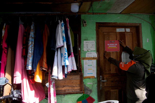 Anggota Satpol PP memantau rumah warga yang sedang isolasi madiri di zona merah COVID-19 RT 006 RW 01, Gandaria Selatan, Cilandak, Jakarta Selatan, Senin (21/6/2021). Foto: Sigid Kurniawan/Antara Foto
