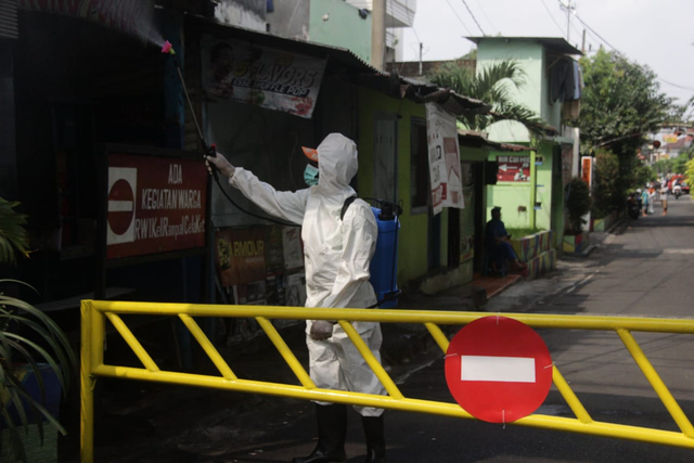 Petugas melakukan penyemprotan desinfektan di Jalan Jaksa Agung Suprapto gang 3, Rampal Celaket, Kota Malang. foto/Rubianto