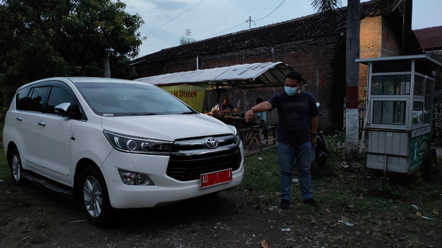Warga menunjukkan mobil dinas Wali Kota Solo Gibran Rakabuming yang diparkir di dekat TPU Cemoro Kembar
