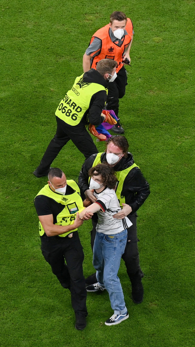 Seorang pengunjuk rasa Jerman ditangkap oleh keamanan sebelum pertandingan Jerman vs Hongaria di Arena Sepak Bola Munich, Munich, Jerman, Rabu (23/6). Foto: Pool via REUTERS/Matthias Hangst