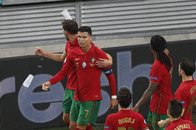Pemain Portugal Cristiano Ronaldo dilempar botol plastik usai merayakan gol kedua saat melawan Prancis. Foto: REUTERS/Laszlo Balogh