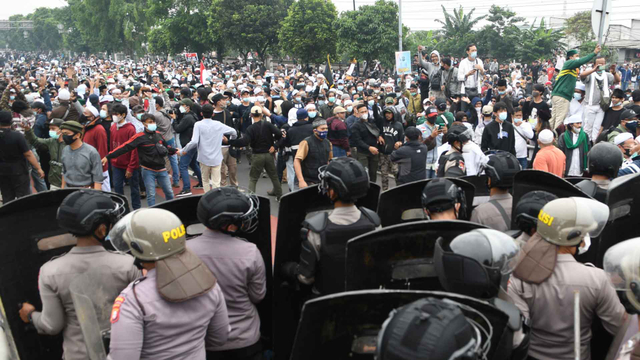 Polisi memblokade massa pendukung Rizieq Shihab di kawasan I Gusti Ngurah Rai saat akan menuju Pengadilan Negeri (PN) Jakarta Timur, Kamis (24/6/2021).  Foto: M Risyal Hidayat/Antara Foto