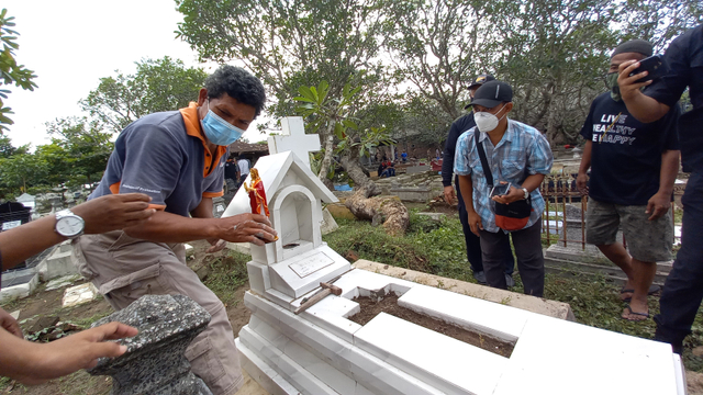 Pekerja memperbaiki makam yang rusak di TPU Cemoro Kembar, Kota Solo
