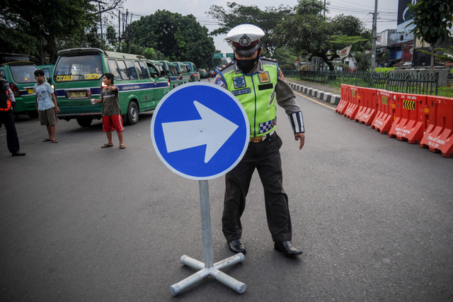 Polisi menaruh rambu lalu lintas saat penutupan akses jalan menuju Jalan Soekarno-Hatta di perbatasan antara Kabupaten Bandung dan Kota Bandung, Jawa Barat. Foto: Raisan Al Farisi/Antara Foto