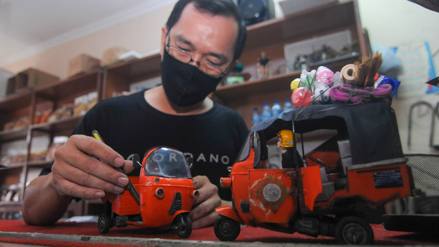 Seorang perajin membuat kerajinan miniatur bajaj di Sidomukti, Salatiga, Jawa Tengah, Senin (28/6/2021). Foto: ANTARA FOTO/Aloysius Jarot Nugroho