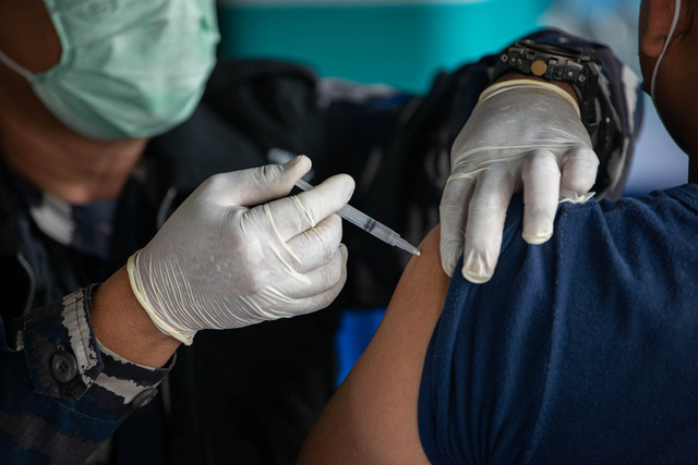 Petugas TNI Angkatan Laut (AL) menyuntikkan vaksin COVID-19 kepada pelaku usaha perikanan di Pelabuhan Perikanan Muara Angke, Penjaringan, Jakarta, Selasa (29/6/2021).  Foto: Aditya Pradana Putra/ANTARA FOTO
