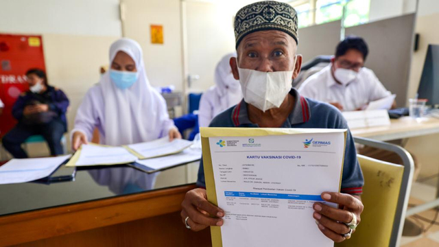Seorang Lansia di Aceh menunjukkan kartu vaksinasi. Foto: Suparta/acehkini