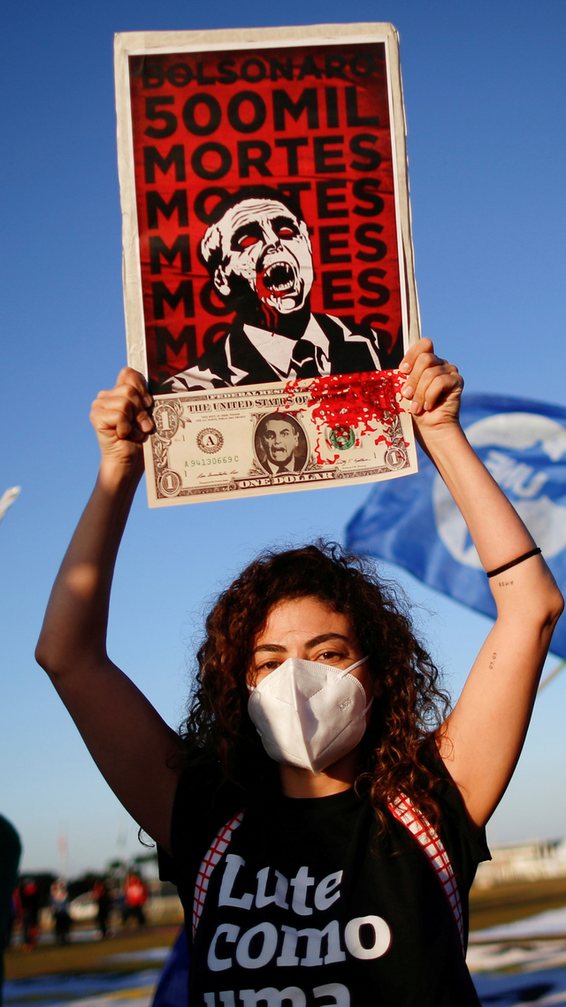 Demonstran mengangkat poster dengan gambar Presiden Brasil Jair Bolsonaro selama aksi protes terhadap Presiden Brasil Jair Bolsonaro di Brasilia, Brasil Rabu (30/6). Foto: Ueslei Marcelino/REUTERS