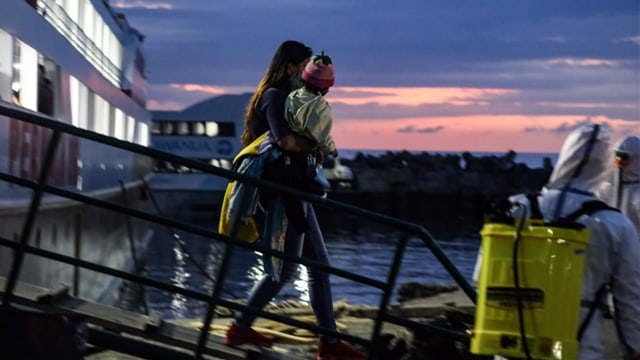 Seorang ibu menggendong anaknya turun dari kapal laut penumpang di Pelabuhan Manado.(foto: febry kodongan/manadobacirita